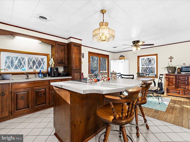 kitchen featuring light tile patterned floors, visible vents, a sink, and light countertops