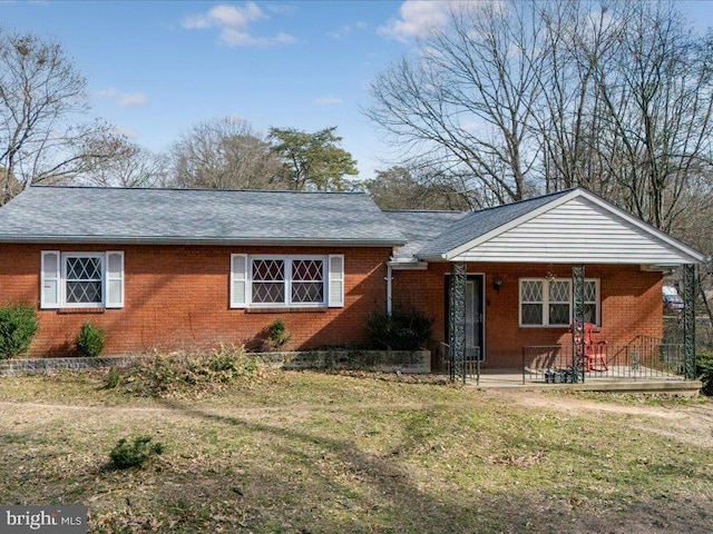 single story home featuring brick siding and a front yard