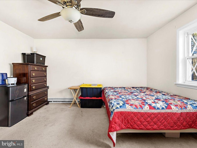 carpeted bedroom featuring a baseboard heating unit, freestanding refrigerator, and ceiling fan