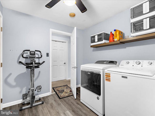 laundry room featuring baseboards, laundry area, wood finished floors, a ceiling fan, and separate washer and dryer