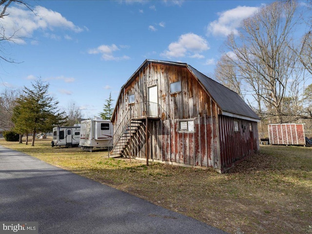 view of outdoor structure with driveway, stairs, and an outdoor structure