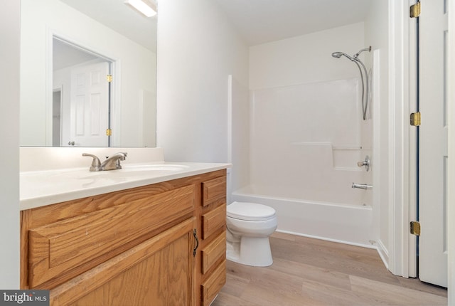 full bath featuring shower / bathing tub combination, toilet, wood finished floors, and vanity