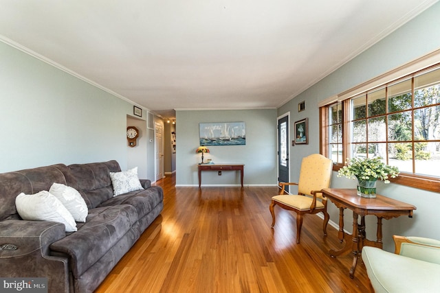 living area featuring crown molding, wood finished floors, baseboards, and visible vents