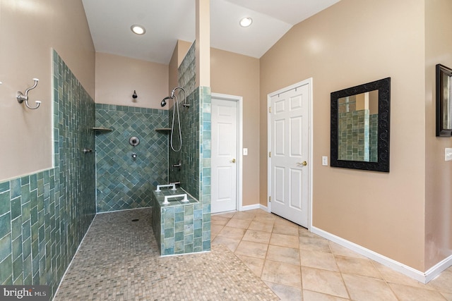 full bath featuring tile patterned floors, a walk in shower, baseboards, and vaulted ceiling