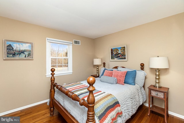 bedroom featuring visible vents, baseboards, and wood finished floors