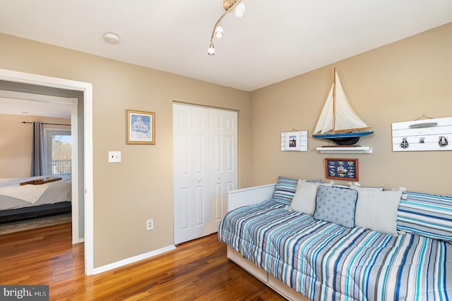 bedroom featuring wood finished floors, a closet, and baseboards