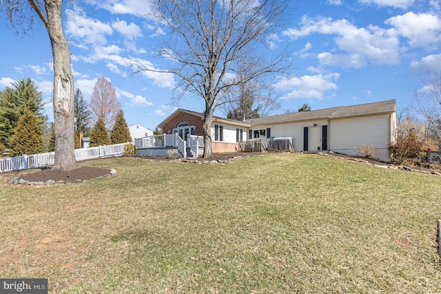 back of property with a yard, fence, and a wooden deck