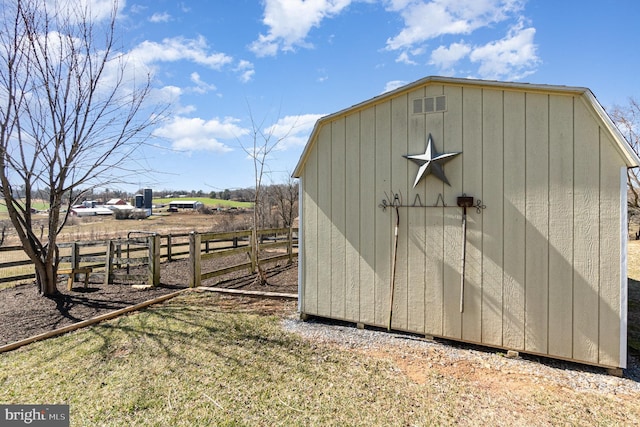 view of shed with a rural view and fence