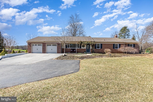 ranch-style home featuring brick siding, a garage, a front lawn, and driveway