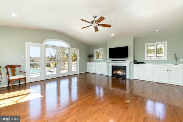 unfurnished living room featuring vaulted ceiling, recessed lighting, a glass covered fireplace, a ceiling fan, and wood-type flooring