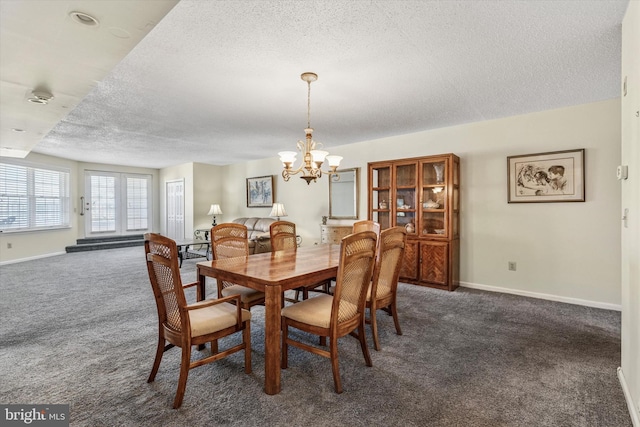 dining area with an inviting chandelier, carpet, baseboards, and a textured ceiling