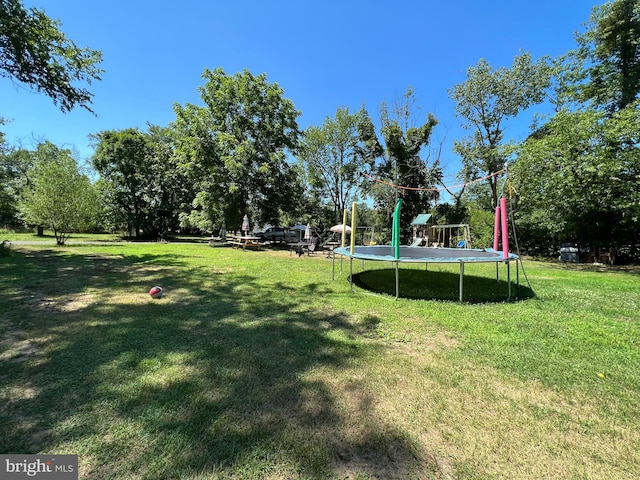 view of yard with a playground and a trampoline