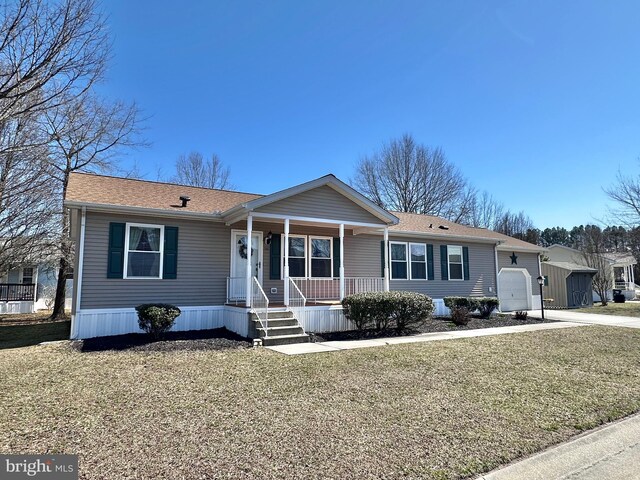 view of front facade featuring concrete driveway, an attached garage, covered porch, and a shingled roof