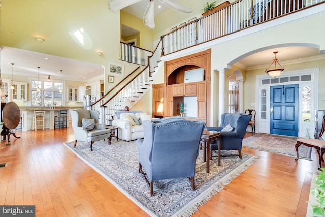 11520 Magnolia Ct, Issue, MD 20645 - living room with arched walkways, light wood-type flooring, ornamental molding, a ceiling fan, and a towering ceiling