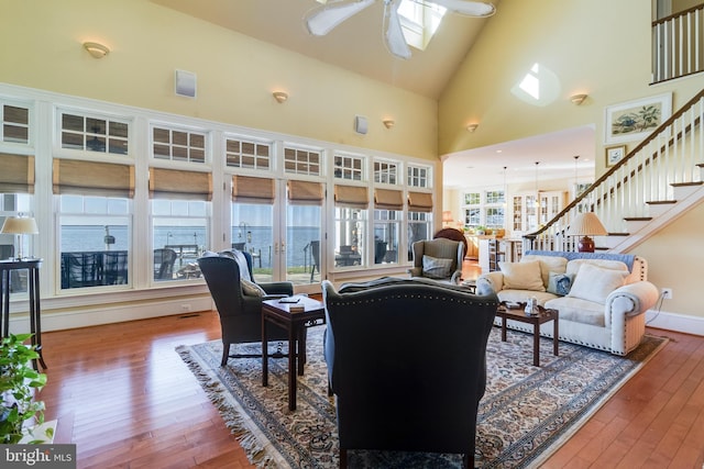 11520 Magnolia Ct, Issue, MD 20645 - living room featuring a ceiling fan, hardwood / wood-style floors, stairs, high vaulted ceiling, and baseboards
