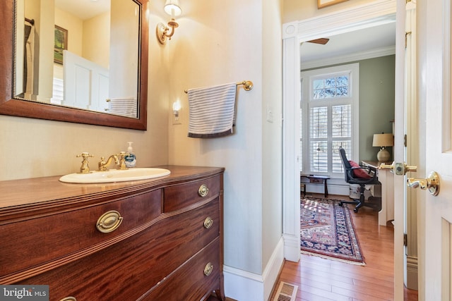 11520 Magnolia Ct, Issue, MD 20645 - bathroom featuring wood finished floors, vanity, crown molding, and baseboards