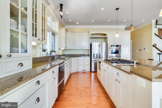 11520 Magnolia Ct, Issue, MD 20645 - kitchen featuring appliances with stainless steel finishes, ornamental molding, a sink, a center island, and light wood-style flooring