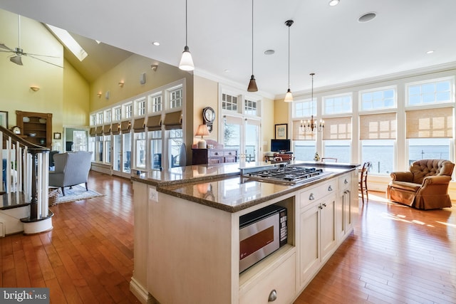 11520 Magnolia Ct, Issue, MD 20645 - kitchen featuring open floor plan, stainless steel appliances, hardwood / wood-style floors, dark stone countertops, and crown molding