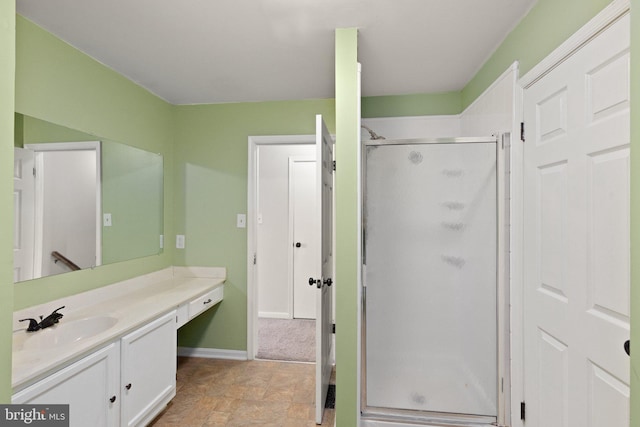 full bathroom with vanity, baseboards, and a stall shower