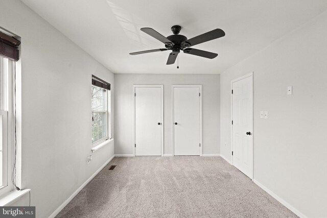 unfurnished bedroom with visible vents, baseboards, carpet floors, and ceiling fan