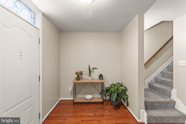 entrance foyer with stairs, baseboards, and wood finished floors