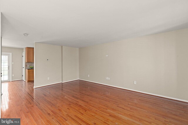 spare room featuring baseboards and light wood-type flooring