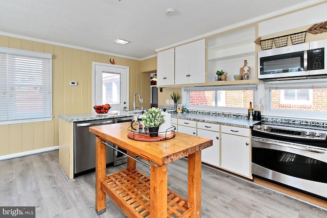 kitchen featuring crown molding, light wood-type flooring, appliances with stainless steel finishes, white cabinetry, and open shelves