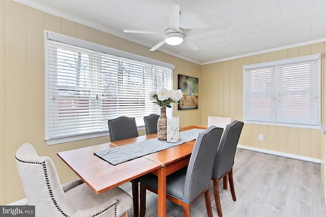 dining room featuring baseboards, crown molding, ceiling fan, and wood finished floors