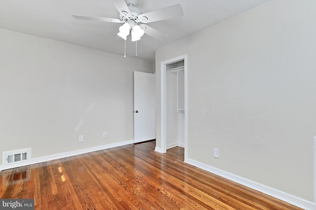 empty room featuring visible vents, baseboards, wood finished floors, and a ceiling fan