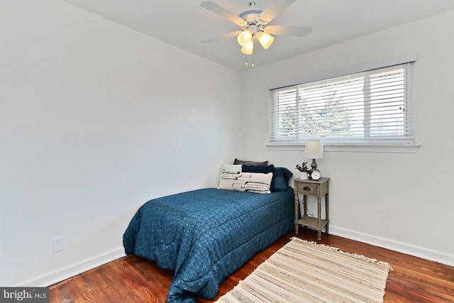 bedroom featuring ceiling fan, baseboards, and wood finished floors