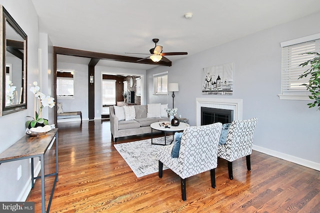 living area with ceiling fan, baseboards, wood finished floors, and a fireplace