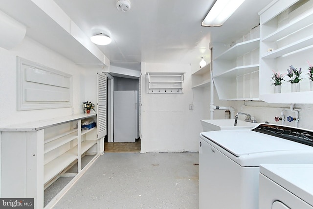 laundry area with laundry area, independent washer and dryer, and a sink