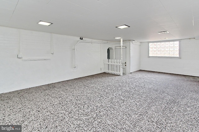 unfurnished room featuring speckled floor and concrete block wall