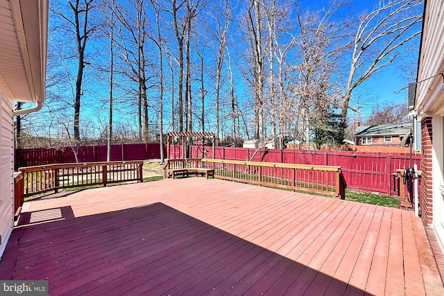 wooden deck with a fenced backyard and a playground