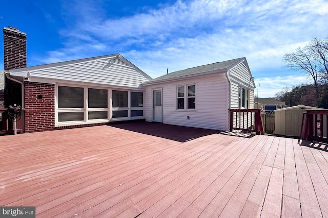 wooden deck with an outbuilding and a storage shed