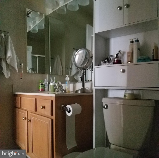 bathroom featuring a shower with shower door and vanity