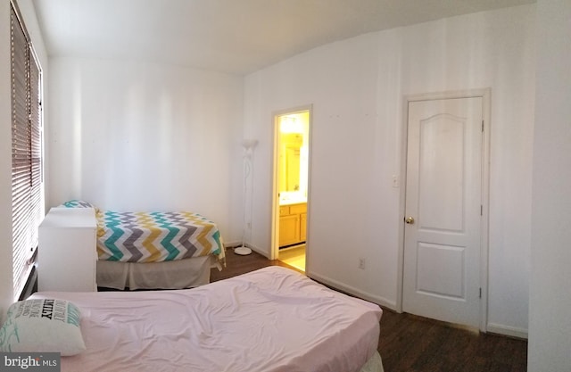 bedroom featuring wood finished floors, baseboards, and connected bathroom