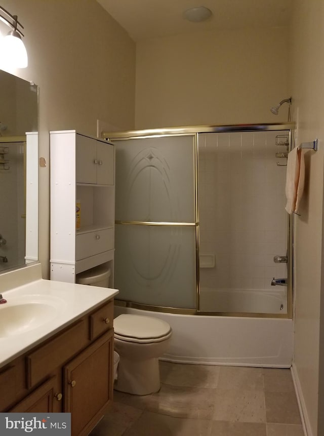 bathroom with vanity, toilet, and bath / shower combo with glass door