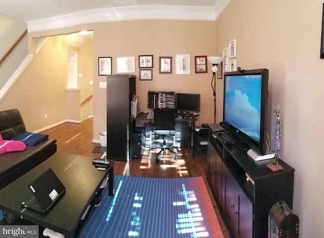 living area with baseboards, wood finished floors, and crown molding