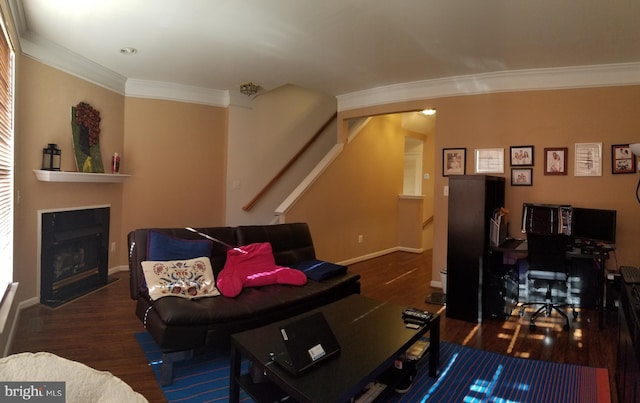 living area featuring stairs, a fireplace with flush hearth, wood finished floors, and ornamental molding