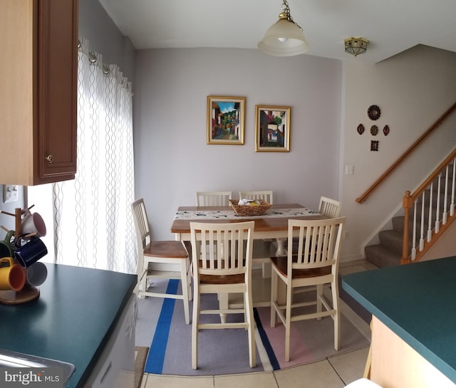 dining space with light tile patterned flooring and stairway