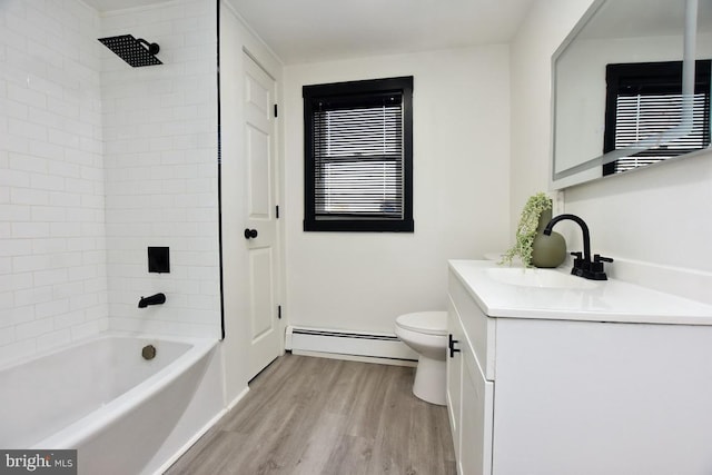 bathroom with toilet, baseboard heating, bathing tub / shower combination, wood finished floors, and vanity