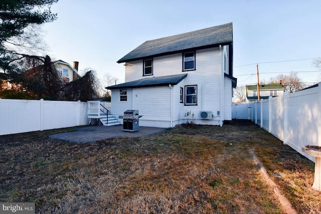 back of property featuring a gate, a lawn, a fenced backyard, and a patio area