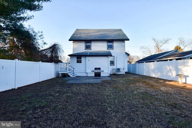 rear view of property with a lawn, a patio, and a fenced backyard