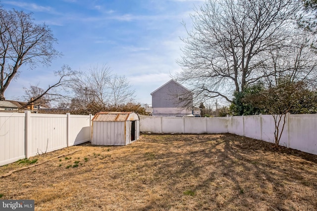 view of yard featuring an outbuilding, a shed, and a fenced backyard