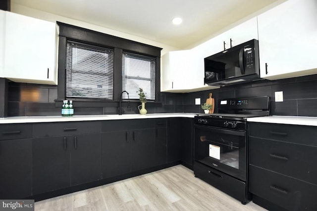 kitchen featuring white cabinets, black appliances, light countertops, and dark cabinets