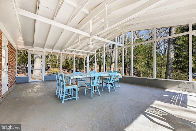 unfurnished sunroom with a ceiling fan and vaulted ceiling