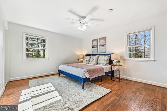 bedroom with multiple windows, baseboards, and hardwood / wood-style floors