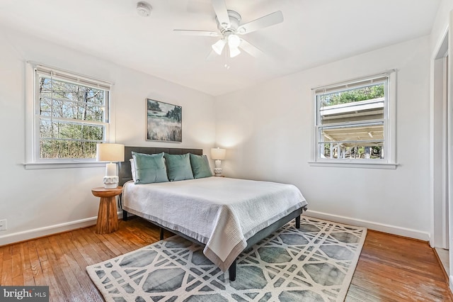 bedroom with hardwood / wood-style floors, baseboards, and ceiling fan