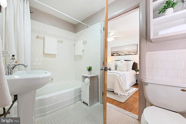 bathroom featuring tile patterned floors, toilet, a ceiling fan, ensuite bath, and shower / bathtub combination